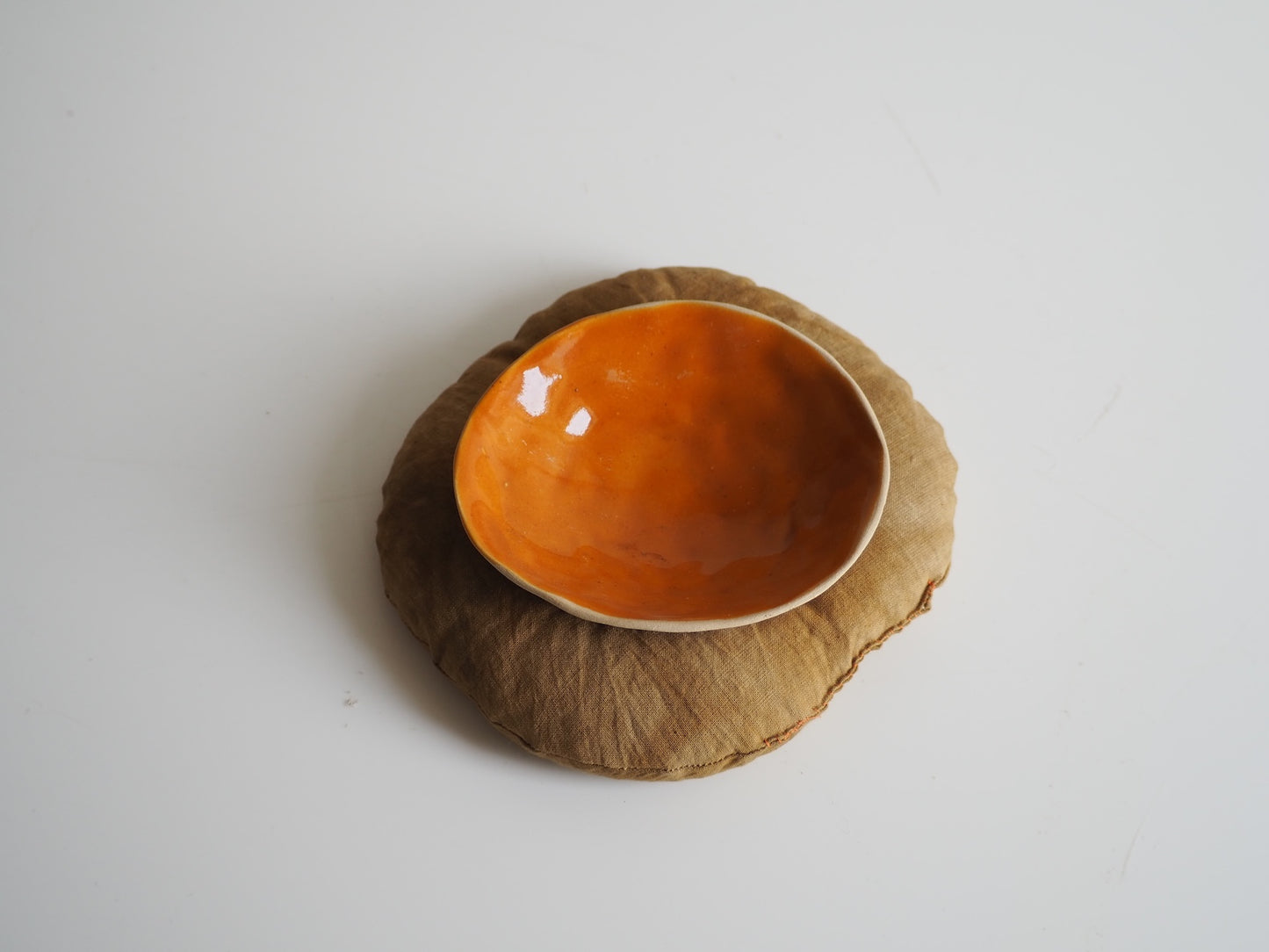 Oranje schaaltje op groen kussentje